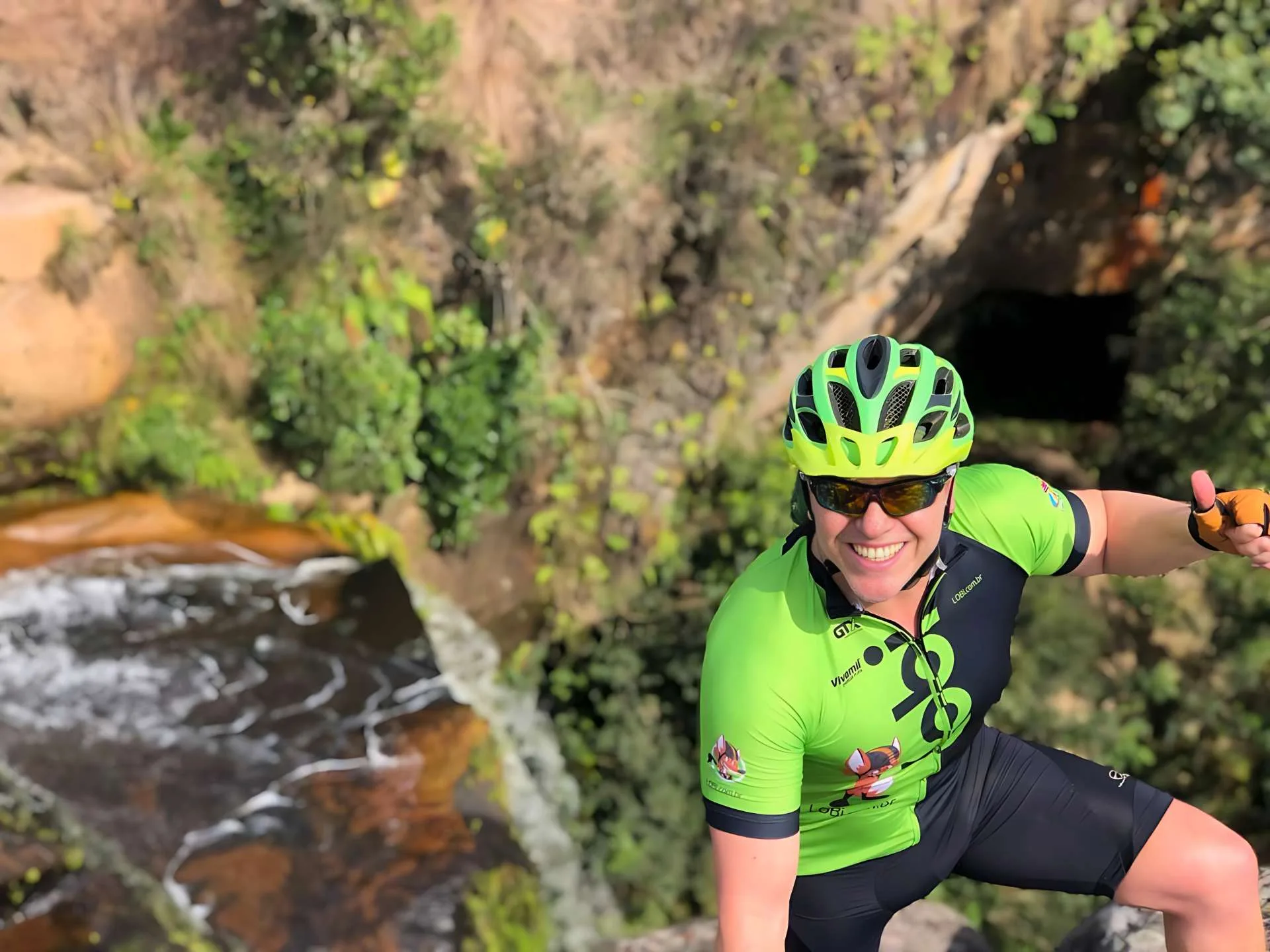 Ciclista Ivan Mendes do Lobi Ciclotur pousa para foto no topo de uma cachoeira no Paraná;