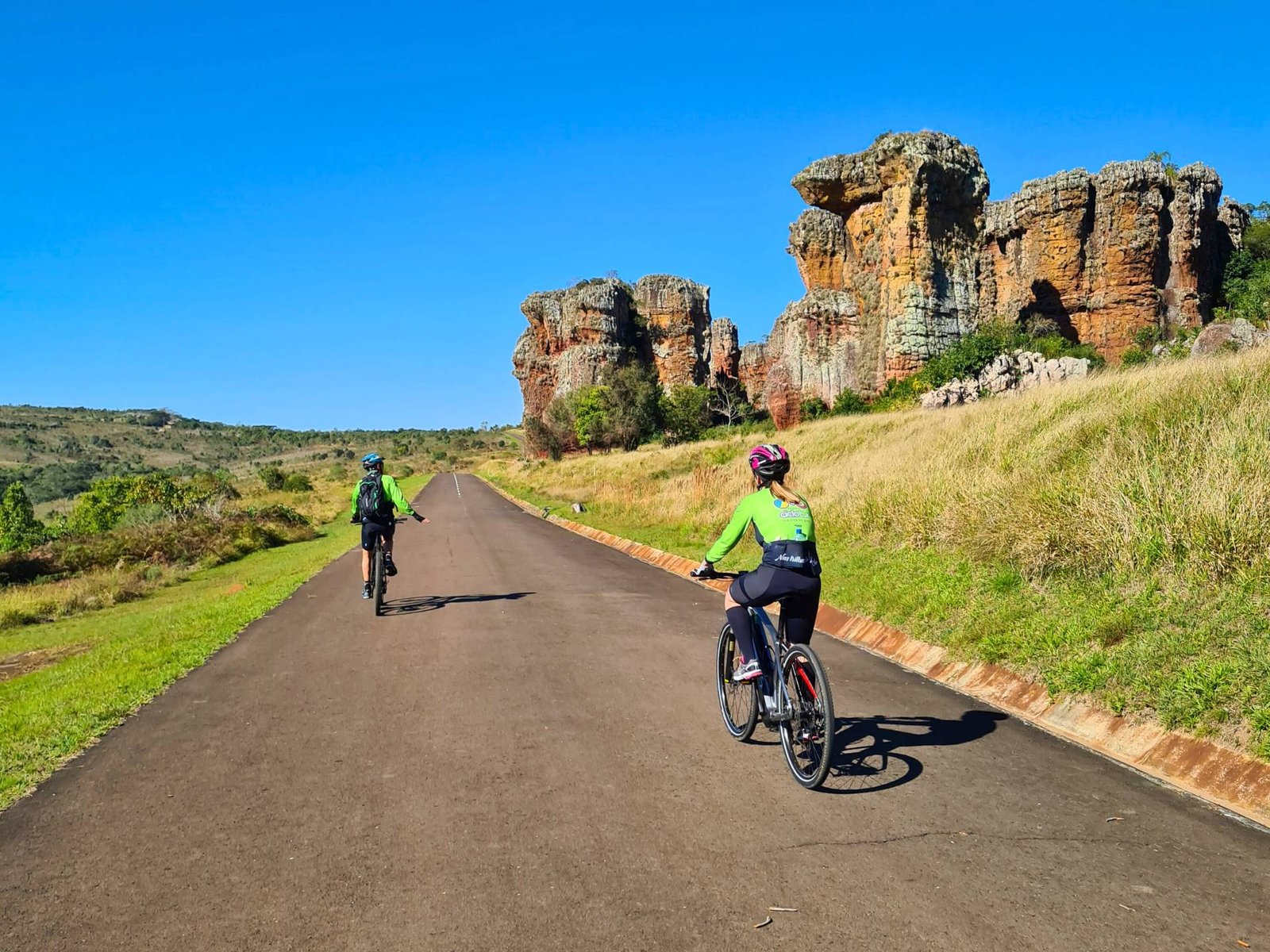 Ciclistas pedalam em meio à natureza, rumo ao horizonte infinito no Dia Nacional do Ciclista Brasileiro.