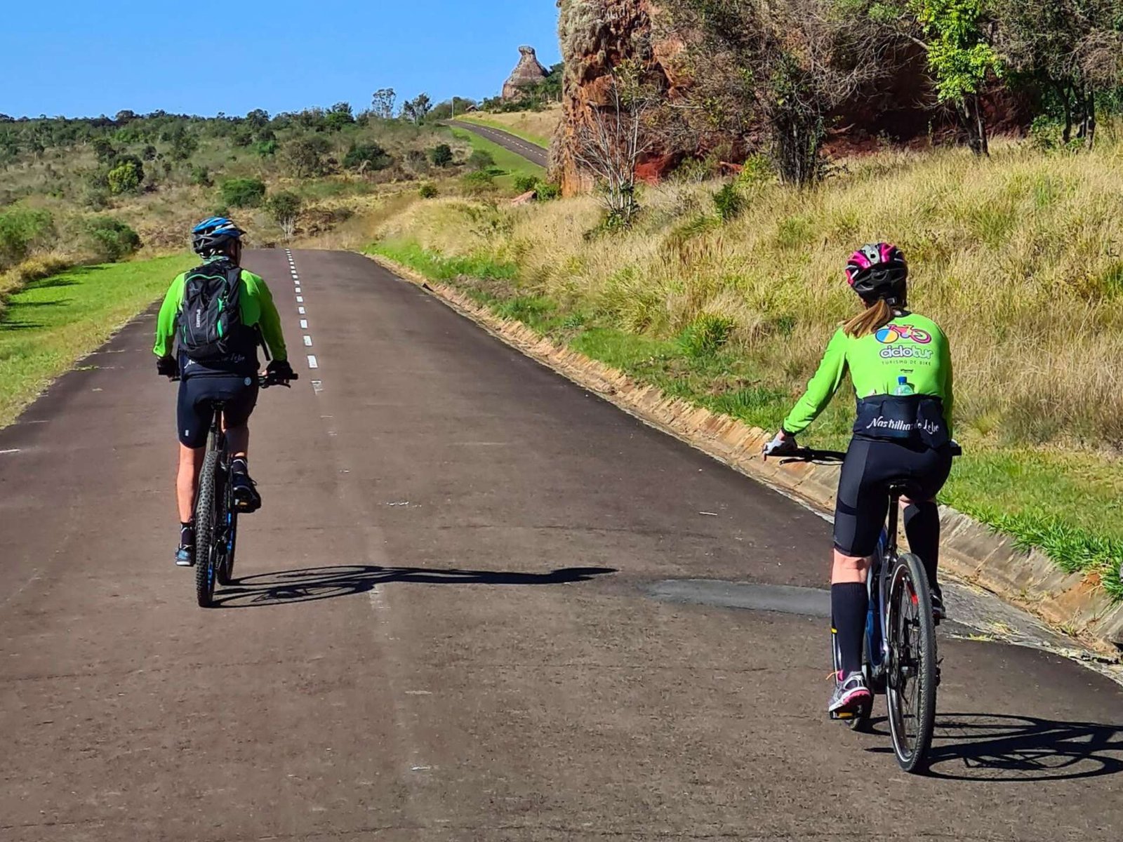 Casal de ciclistas pedala e observa a paisagem em Redefinindo o Conceito de Cicloturismo: Inovações e Tendências Contemporâneas