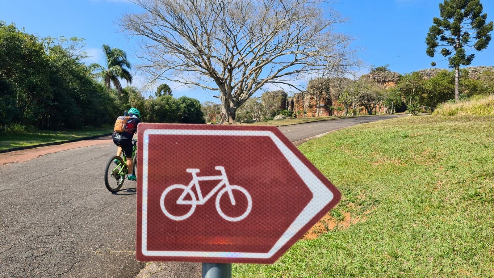 Ciclista utiliza a sinalização direcional de cicloturismo para se guiar nas Rotas de Cicloturismo Autoguiadas.