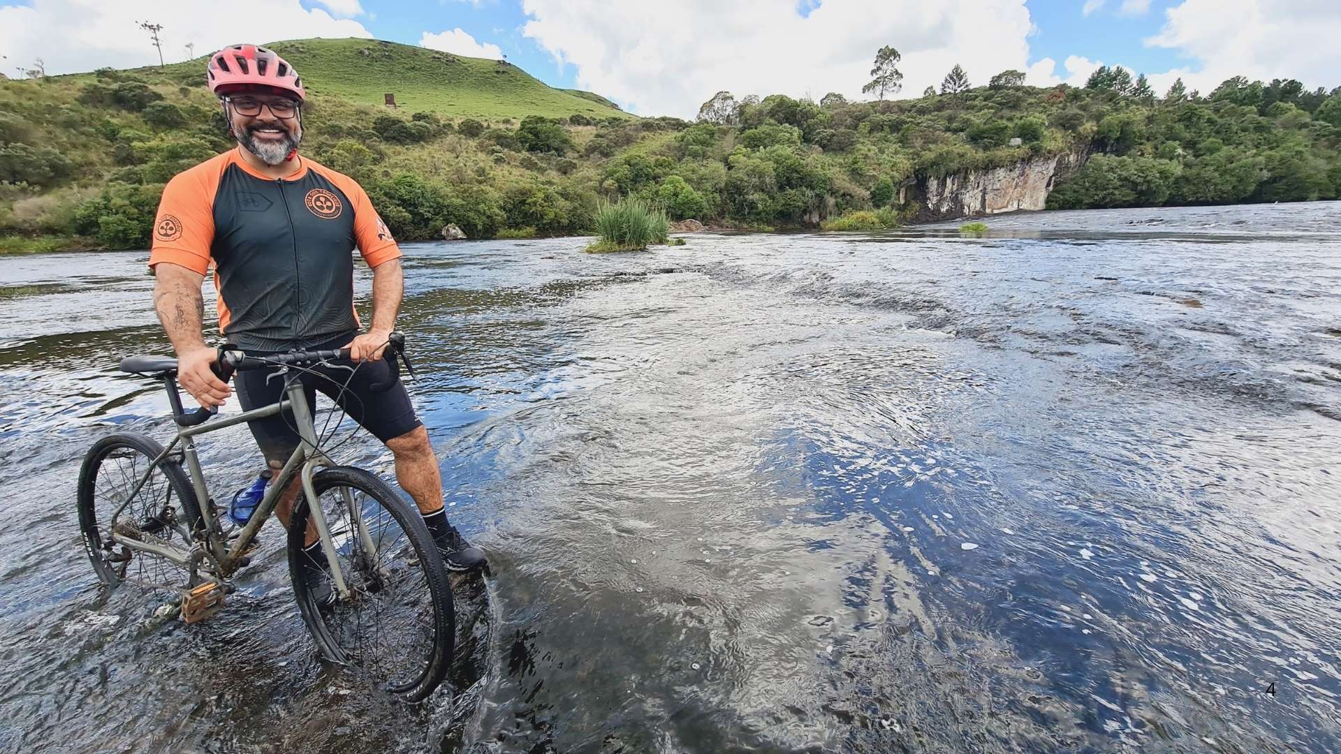 Ciclista atravessa rio praticando Cicloturismo Sustentável na Rota dos Tropeiros em São Francisco de Paula no RS.